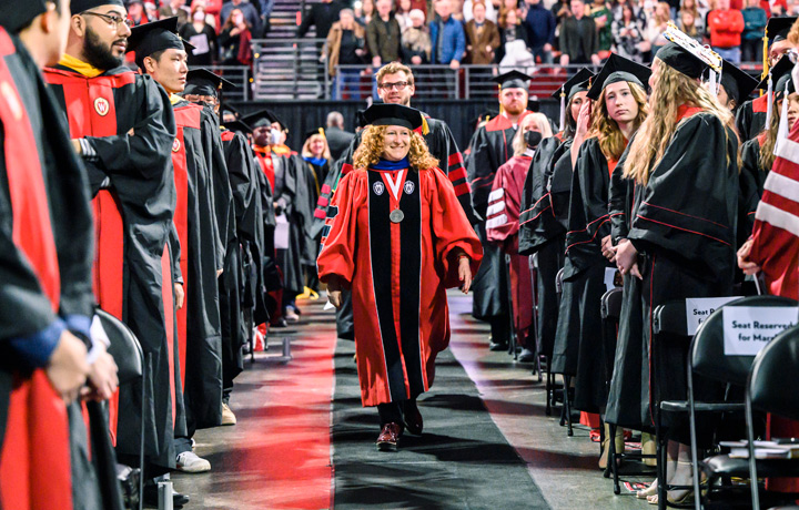 Chancellor Jennifer Mnookin processes toward the stage wearing full academic regalia at her first UW winter graduation ceremony.