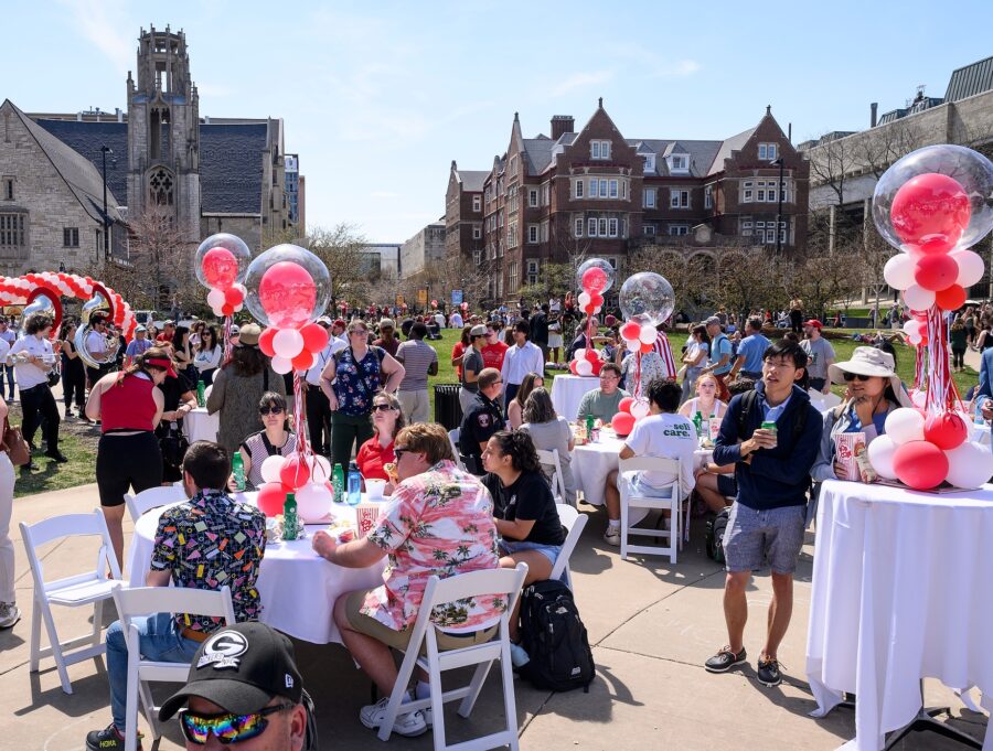 People line up in Library Mall for ice cream, while others relax on the grass and eat ice cream, enjoying the celebration.