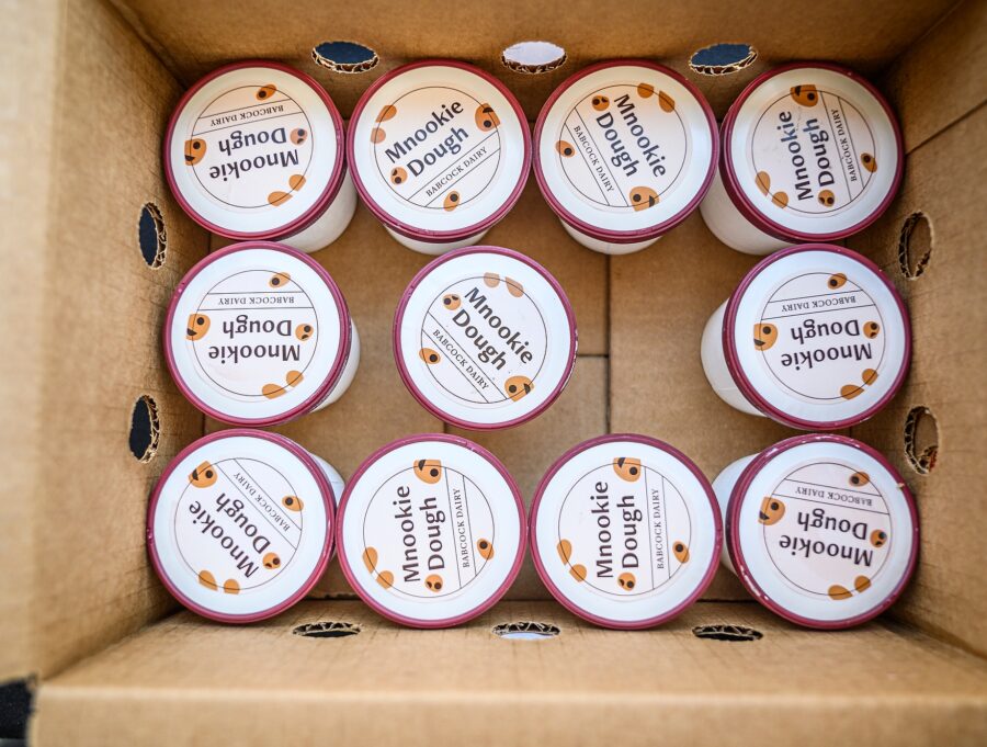 A cardboard box filled with single serving containers of Mnookie Dough ice cream